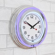 a blue and white clock mounted to the side of a brick wall with two hands