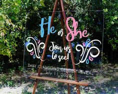 a wooden easel holding a sign that says he or she you're to see