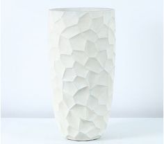 a white vase sitting on top of a table