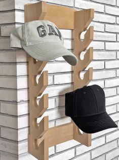 a hat rack with two hats on it and a baseball cap hanging from the wall