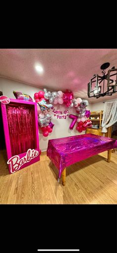 a room decorated with balloons and pink furniture