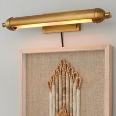 a wall light that is on top of a burlap and wood paneled frame