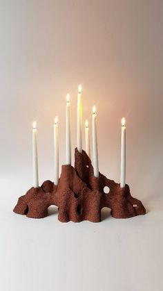 a group of white candles sitting on top of a rock