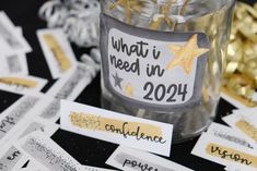 a jar filled with gold and white confetti next to some tags that say what i need in 2014