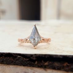 a diamond ring sitting on top of a piece of wood in front of a building