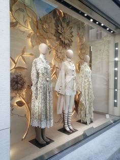 three mannequins dressed in white and beige clothing