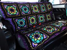 a crocheted seat cover in the back of a car, with an intricate design on it