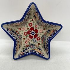 a ceramic star dish with red and blue flowers