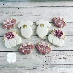 baby shower cookies decorated with pink and white icing on a wooden background, including teddy bears