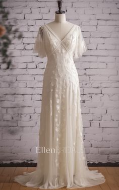 a white wedding dress on a mannequin stand in front of a brick wall