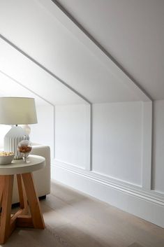 a white couch sitting next to a table on top of a hard wood floor in a room