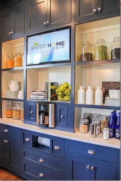 a kitchen with blue cabinets and shelves filled with various items, such as cereals