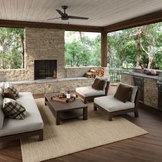 a living room filled with furniture and a fire place in the middle of a wooden floor