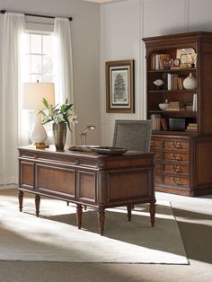 an office desk in front of a large window