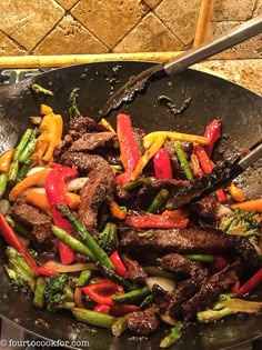 stir fry with beef, peppers and broccoli in a wok