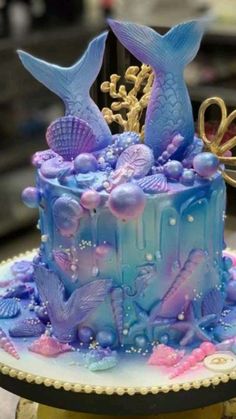 a blue and purple cake with sea creatures on it's side, sitting on top of a table