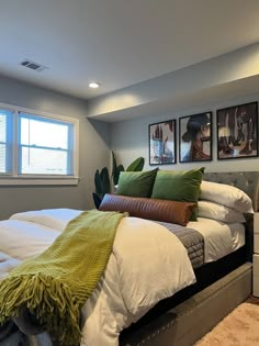 a bed with white sheets and green pillows