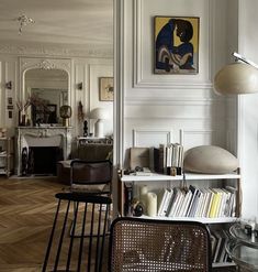 a living room filled with furniture and a painting on the wall above it's bookshelf