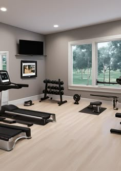 an exercise room with treadmills and television