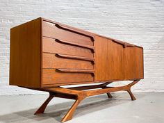 a wooden dresser sitting on top of a cement floor