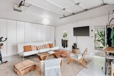 a living room filled with furniture and a flat screen tv mounted to the side of a wall