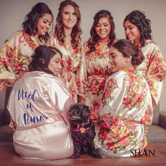 the bride and her bridesmaids pose with their dog for a photo in matching robes