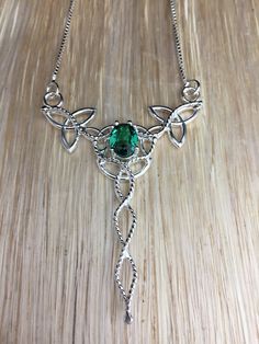 I've designed this entirely in sterling silver, and everything is handmade and created into a Celtic Trinity Knot pendant necklace with an 8x6mm oval lab Emerald, which is set in a heavy 4 prong setting. The lab-created gems means they were created in a laboratory environment, but with the same exact chemical properties as earth-made ones, but without the same expense. The base of the pendant is made with a total of 5 Trinity Knots and sterling wire work braids down the center to add the balanci Spiritual Sterling Silver Oval Necklace, Oval Sterling Silver Birthstone Necklaces, Silver Oval Pendant For May Birthstone, Silver Necklace With Emerald Oval Pendant, Silver Oval Pendant With Emerald For May Birthstone, Silver Oval Pendant With Emerald, Oval Sterling Silver Wedding Necklaces, Work Braids, Gem Meaning