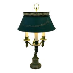 a table lamp with a green shade on the top and two candles in the bottom