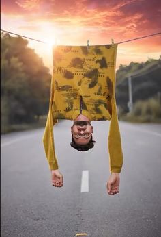 a man hanging upside down from a clothes line with his head in the air,