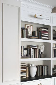 the bookshelf is filled with many different types of books and vases on it