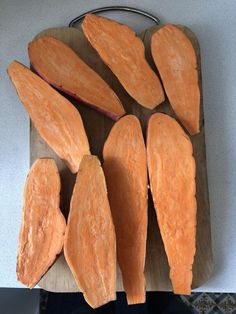 several pieces of carrot sitting on top of a wooden cutting board