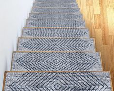 a set of blue and white rugs sitting on the side of a wooden floor