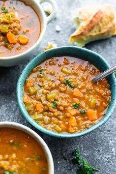 two bowls of soup with bread on the side