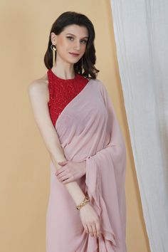 Be it a cocktail party or a day event, put your best foot forward in this stunning frilly saree! With an embellishments red halter neck blouse and a monotone hued blush pink saree, this combination is an eclectic choice for days when you want your look to be chic and sophisticated.Style Blush pink hue Halter neck blouse Frilly Saree Contrasting Combination Georgette fabric Specifications Model height - 5'7" Model wearing - S Sleeveless Georgette Party Blouse, Georgette Tops For Party With Traditional Drape, Party Tops In Georgette With Traditional Drape, Party Top With Traditional Drape In Georgette, Pink Traditional Drape Blouse For Summer, Pink Pre-draped Saree For Summer, Pink Traditional Drape Top For Party, Pink Top With Traditional Drape For Parties, Festive Pink Georgette Top