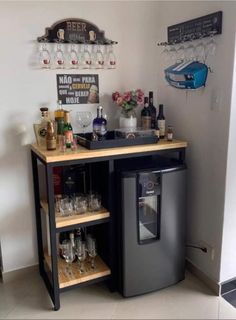 a small bar with wine glasses and liquor bottles on the top shelf next to it