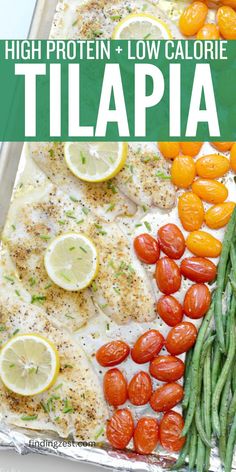 A sheet pan with a row of four tilapia, a row of red and orange cherry tomatoes and a row of fresh green beans. Lemon slices and fresh chives are on top of the tilapia seasoned with lemon pepper.