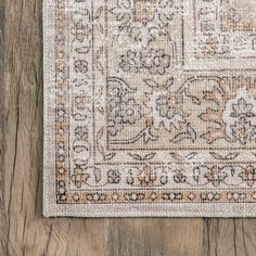 an area rug on top of a wooden floor with a wood floor in the background