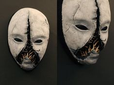 two masks with mouths and teeth are hanging on the wall