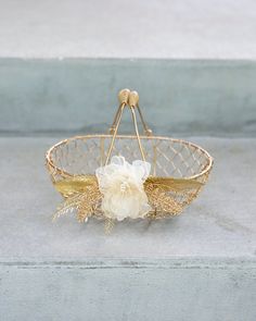 a white flower in a gold wire basket