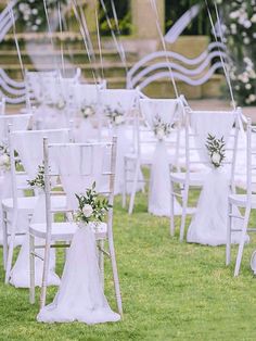 rows of chairs with white sashes and flowers on them are set up for an outdoor ceremony