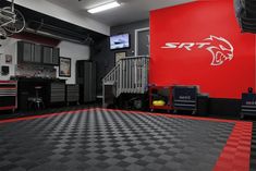 a garage with black and red checkered flooring, two bikes on the wall