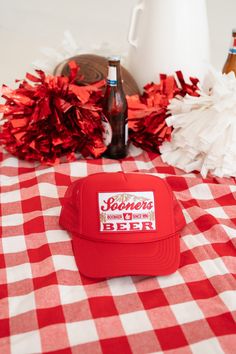 a red and white checkered table cloth with beer bottles, pom poms