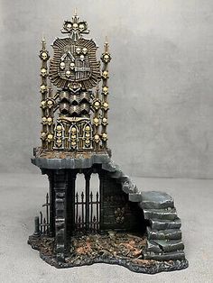 an ornate iron throne with skulls on it's head and stairs leading up to the top