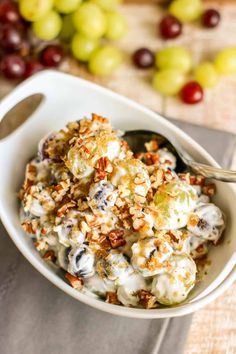 a white bowl filled with grapes and nuts