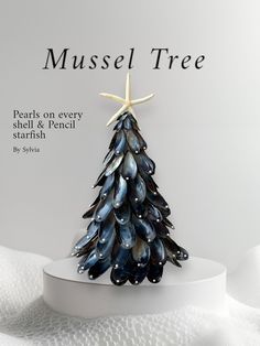 a small christmas tree made out of seashells and starfish on a white plate