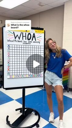 a woman standing next to a white board with a question on it in front of a blue and white checkered floor