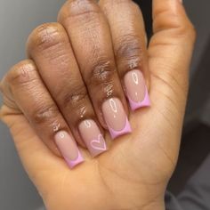 a woman's hand with pink and white nail polish on it, holding up her fingers