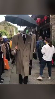 a man in a suit and tie walking down the street with an umbrella over his head