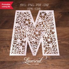 laser cut paper with the letter m on it's side and flowers in the middle