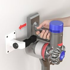 a hand is holding the handle on a wall mounted device